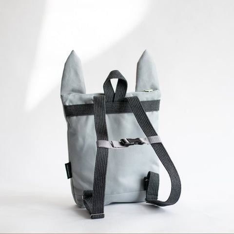 3. Girl sitting with Muni Bunny kids backpack, showing adjustable straps and playful design