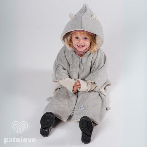 1. Child wearing grey Patulove car poncho with bear ears, sitting and smiling in studio setting