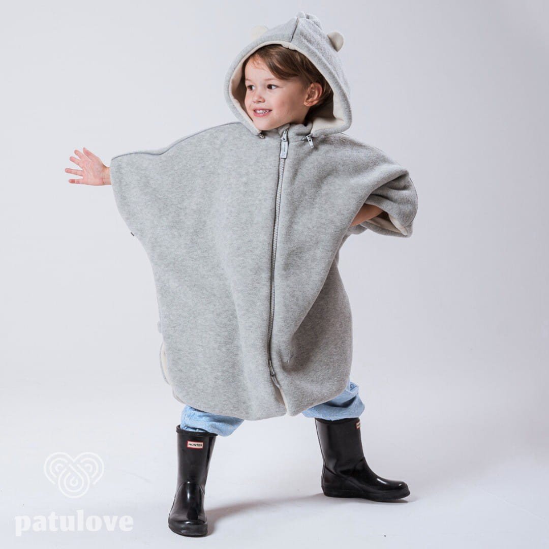 2. Child standing in grey Patulove car poncho with bear ears, arms outstretched, in studio setting
