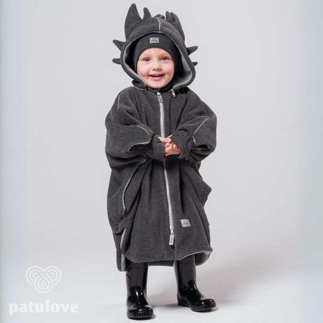 6. Child wearing Patulove dragon-themed car poncho with hood, standing with hands clasped in studio setting