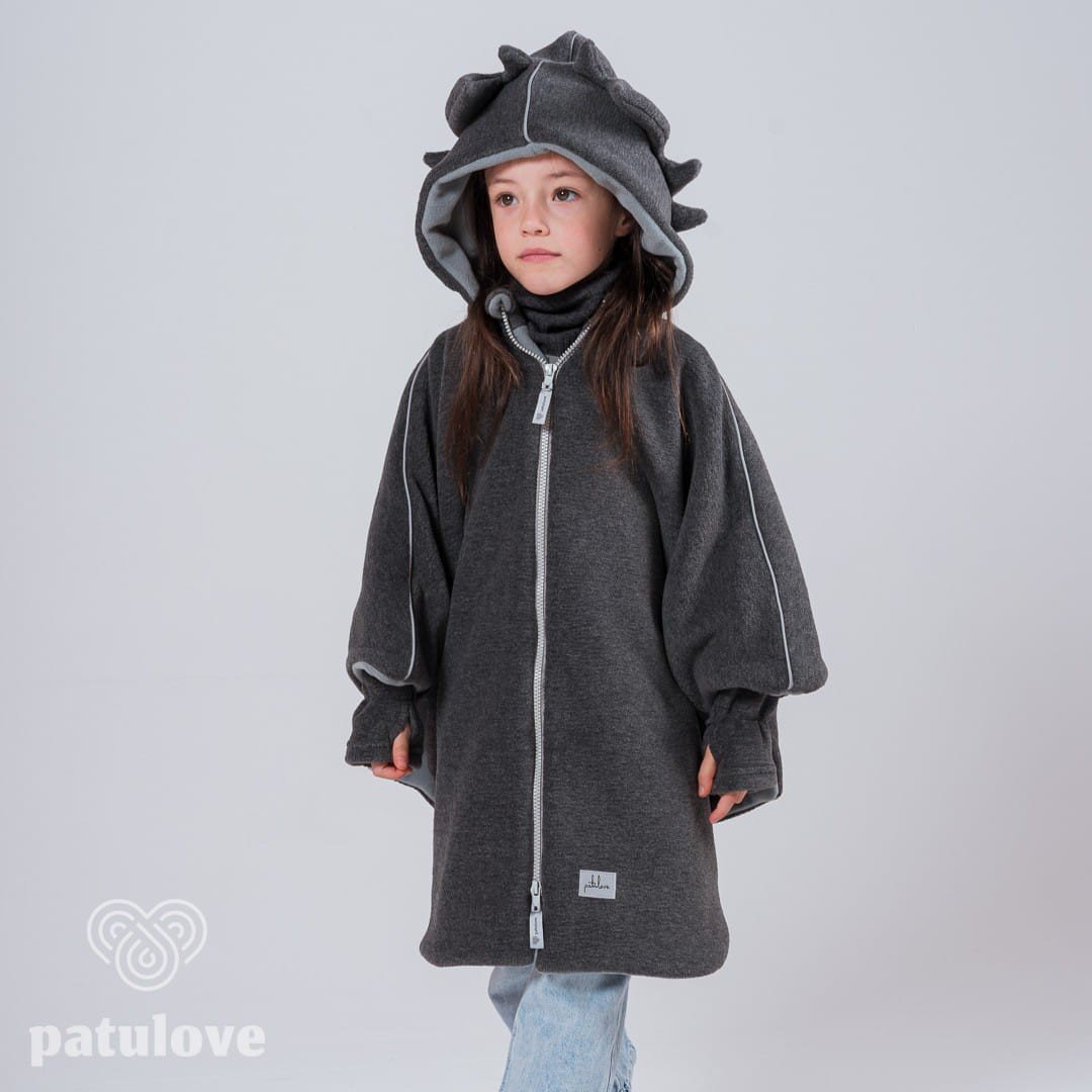 7. Girl wearing Patulove dragon-themed car poncho with hood, standing with hands in pockets in studio setting