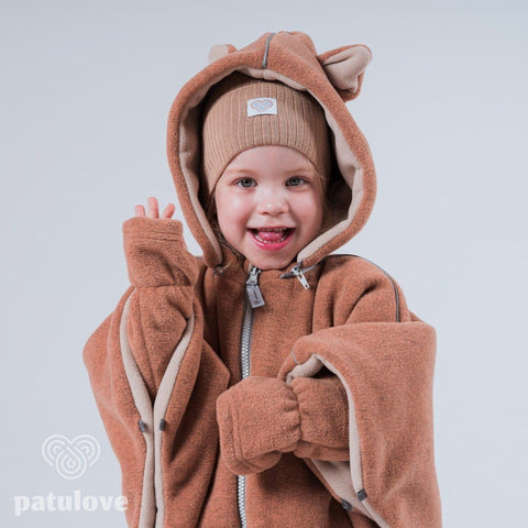 2. Smiling child in Patulove fox car poncho with hood and matching beanie, showing front zipper detail