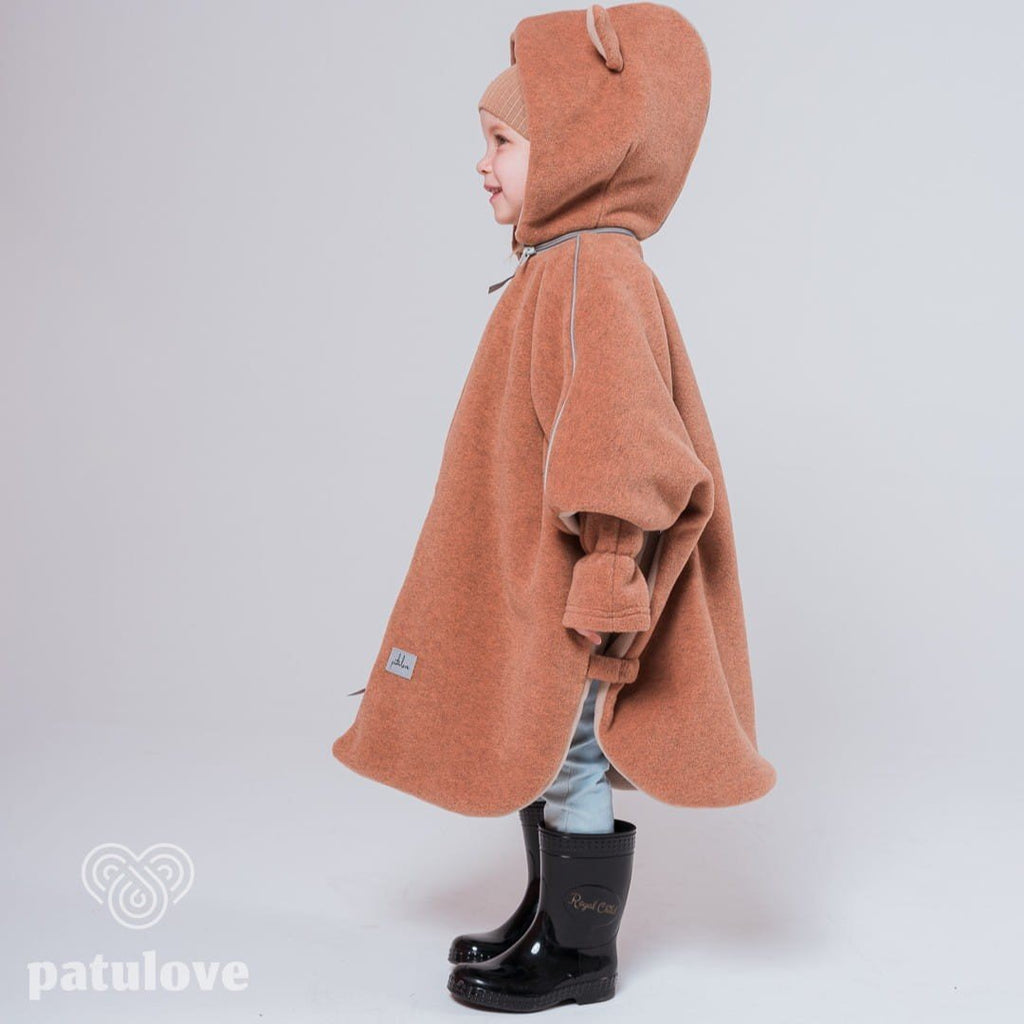 8. Side profile of child in Patulove fox car poncho with hood and black boots, showing logo detail