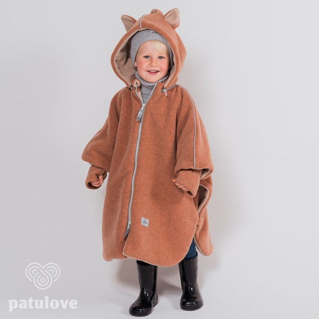 9. Child in Patulove fox car poncho with hood and grey beanie, standing with hands in pockets