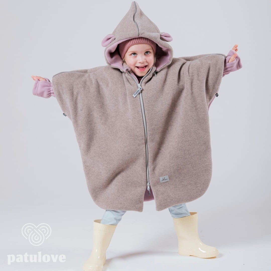 1. Child wearing Patulove pink lamb car poncho with hood and yellow boots, arms outstretched in studio setting