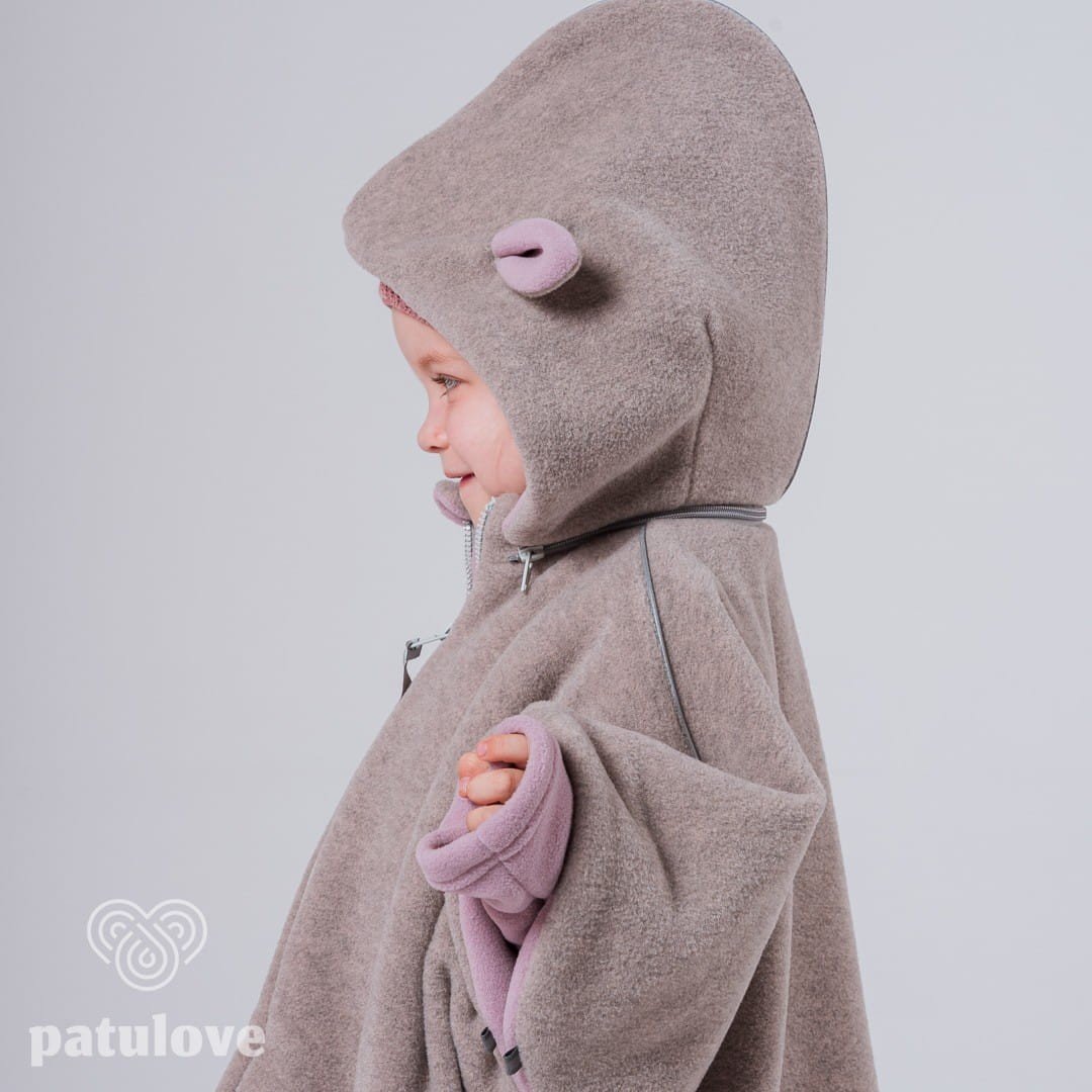 2. Side view of child in Patulove pink lamb car poncho with hood, showing magnetic fasteners
