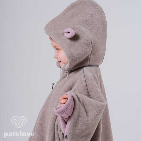 2. Side view of child in Patulove pink lamb car poncho with hood, showing magnetic fasteners