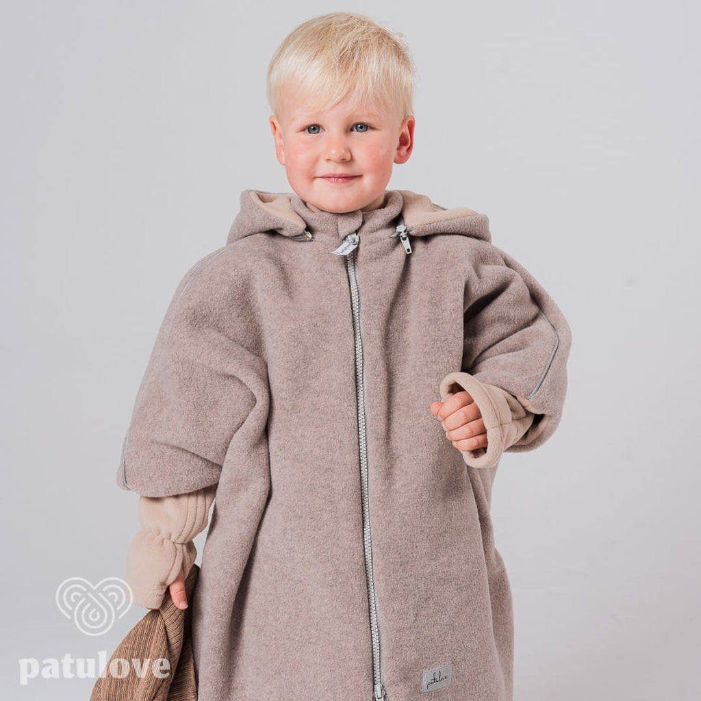 1. Boy wearing Patulove lamb beige car poncho with hood, holding brown hat in studio