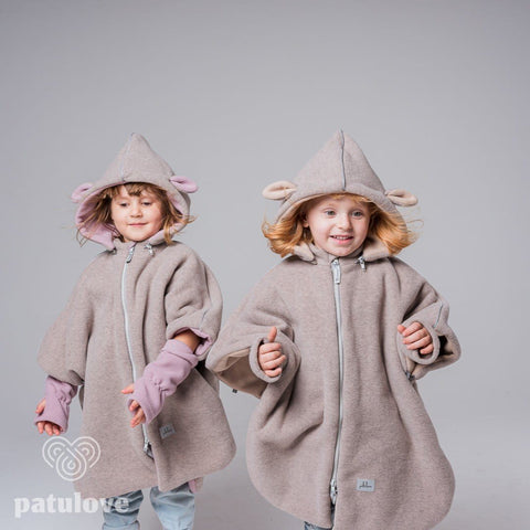 1. Two children wearing Patulove lamb beige car ponchos with hoods, playing in studio