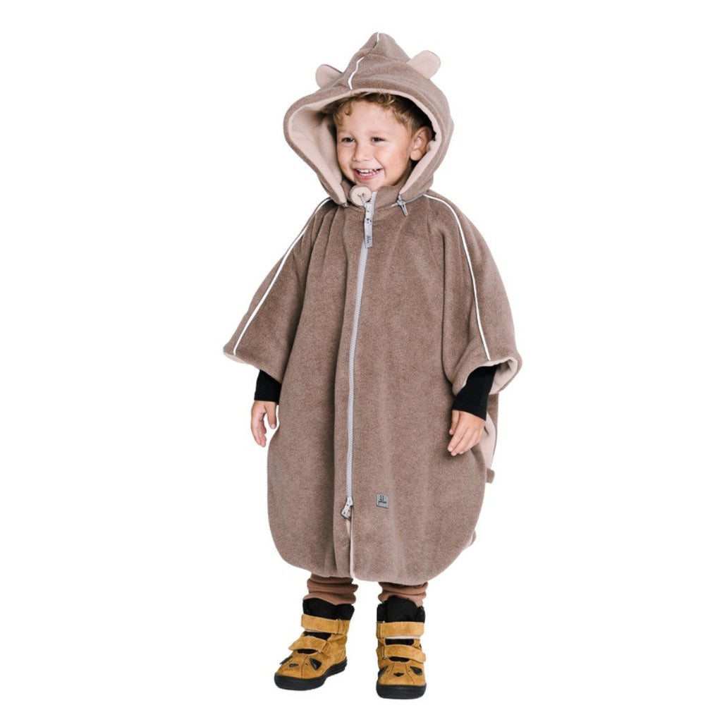 6. Boy wearing brown Patulove car poncho with bear ears, standing and smiling in studio