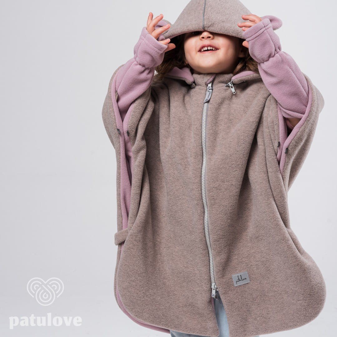 4. Child in Patulove pink lamb car poncho with hood, hands pulling hood down, studio background