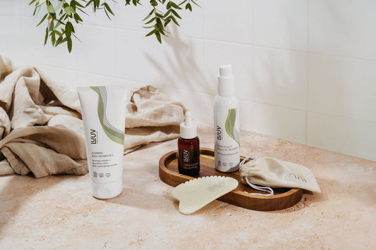 1. LUUV skincare products including Cellulite Treatment COSMOS arranged on a wooden tray in a bathroom setting