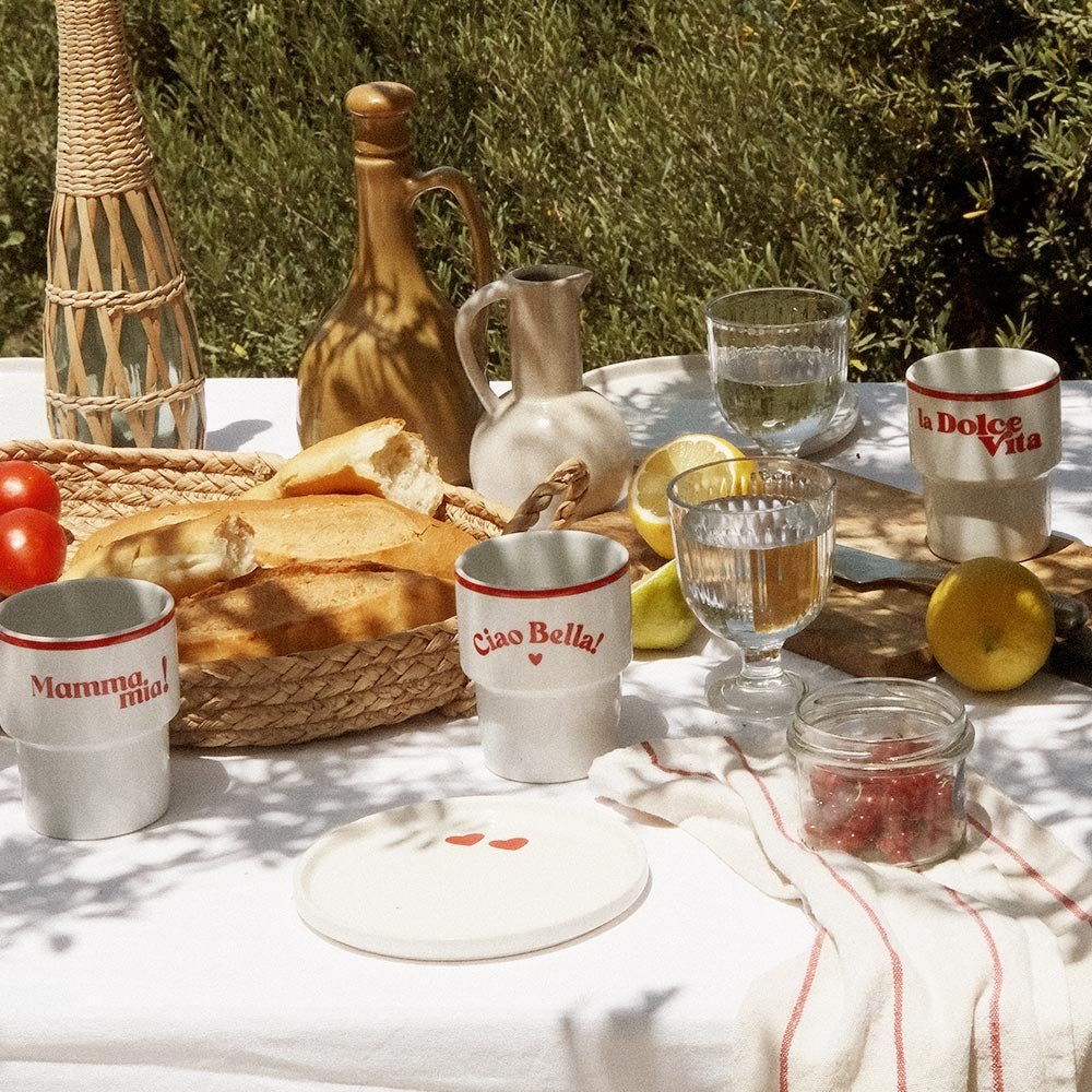 6. Terra Mamma ceramic mugs with 'Mamma Mia!' and 'Ciao Bella!' text on outdoor table with bread and lemons