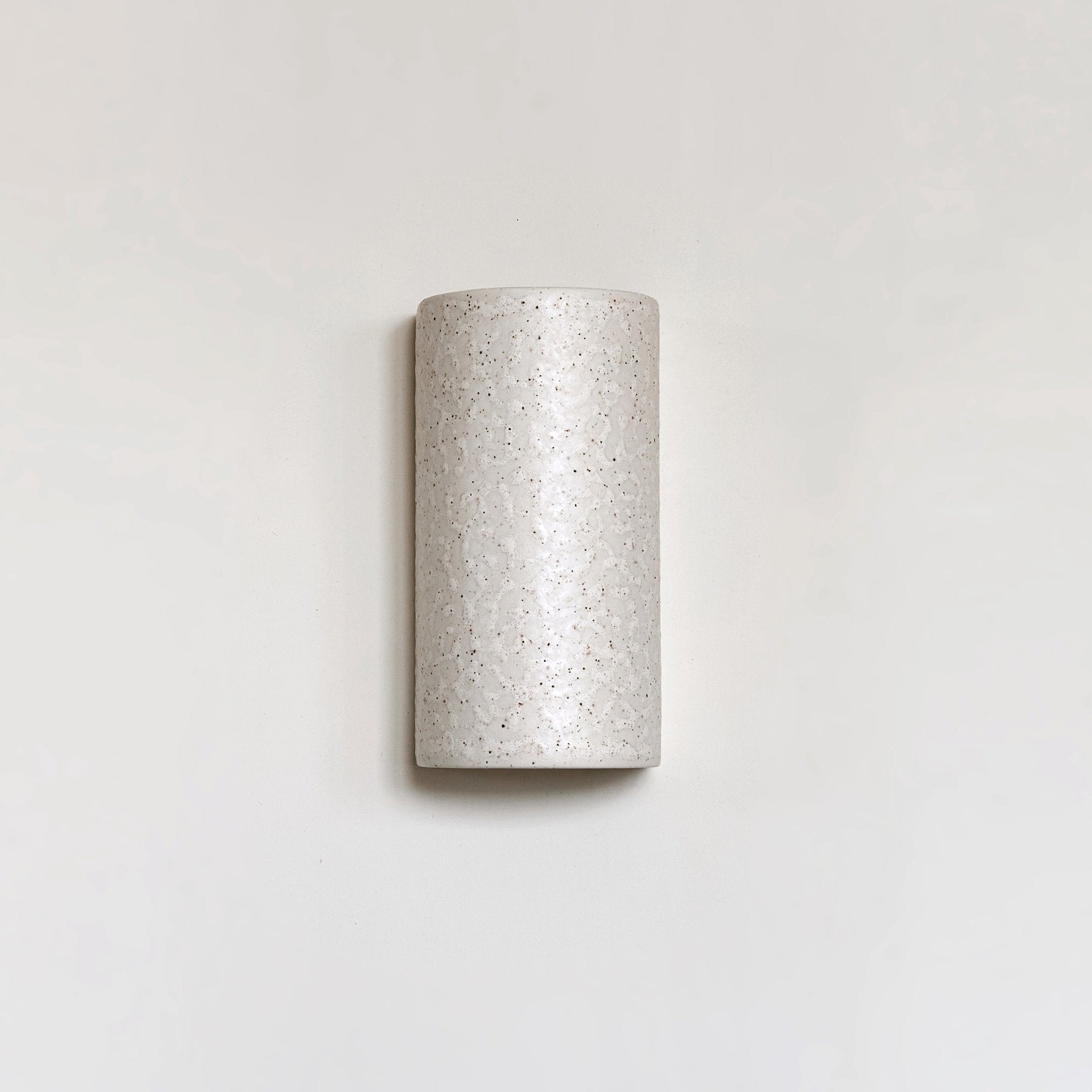 2. Beige spotted brown ceramic wall sconce with minimalist design on plain background