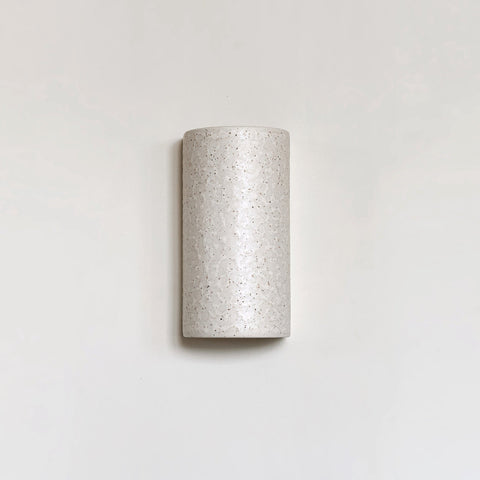 2. Beige spotted brown ceramic wall sconce with minimalist design on plain background
