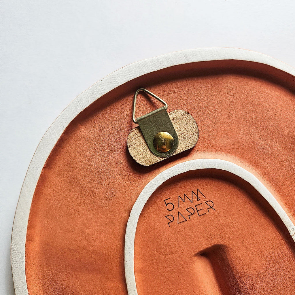 8. Back view of 5mm Paper ceramic wall mask showing hanging mechanism and brand logo