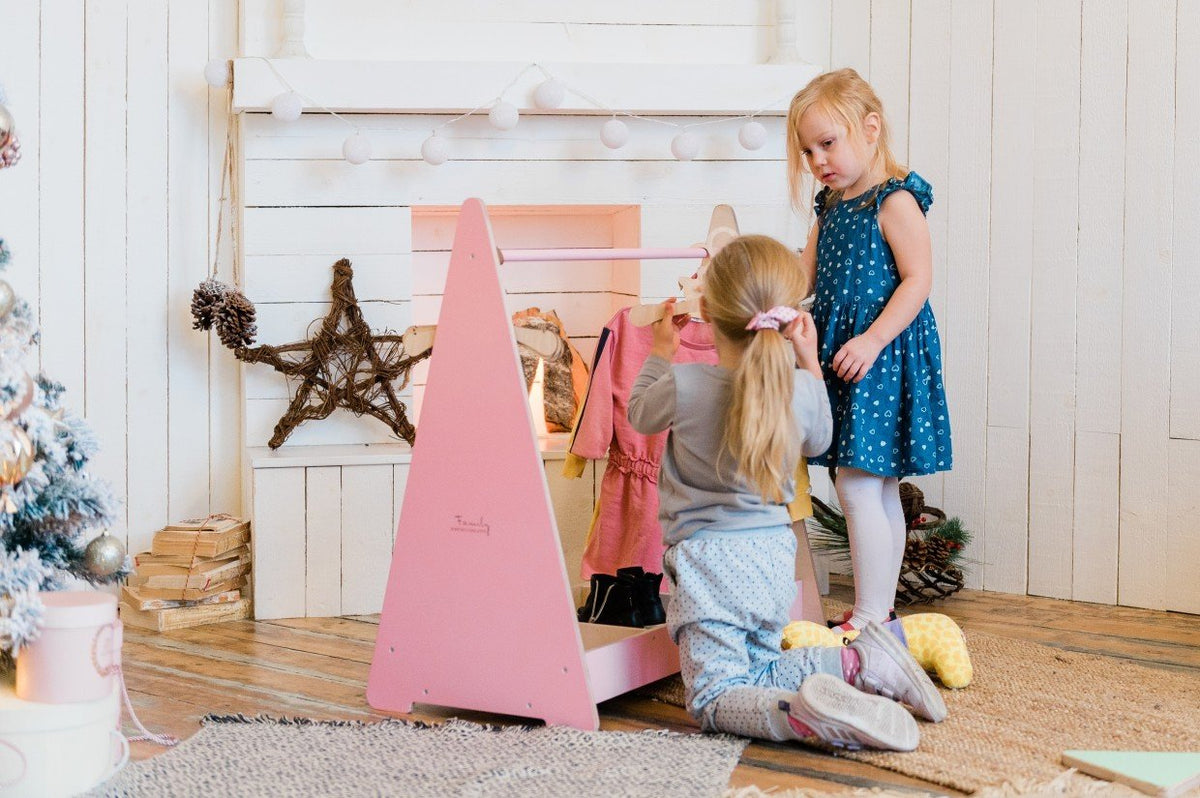 3. Two girls playing with a pink playset in a cozy room with wooden floors