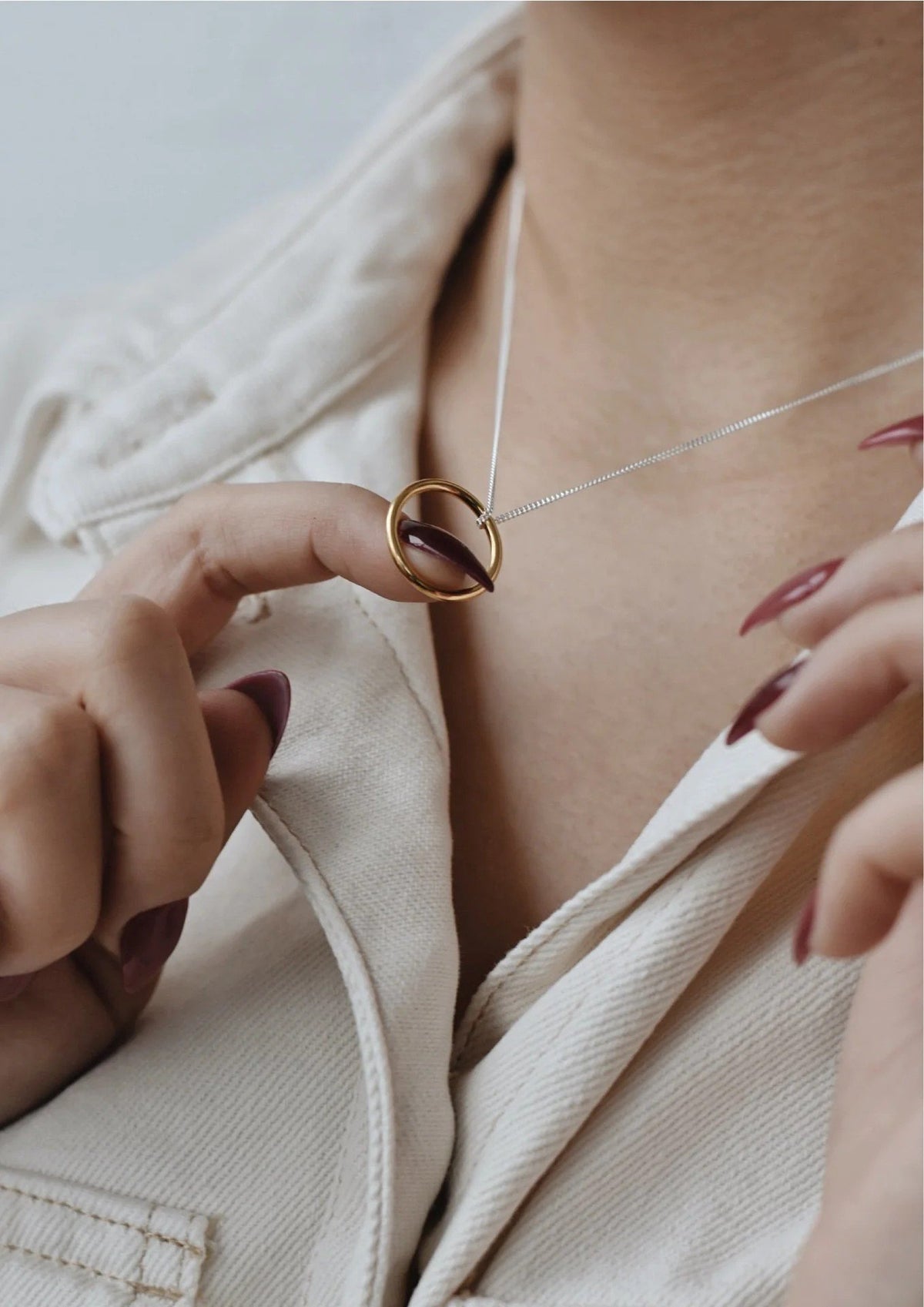 2. Close-up of gold circle pendant necklace on a woman's neck, highlighting the sleek design and gold vermeil finish