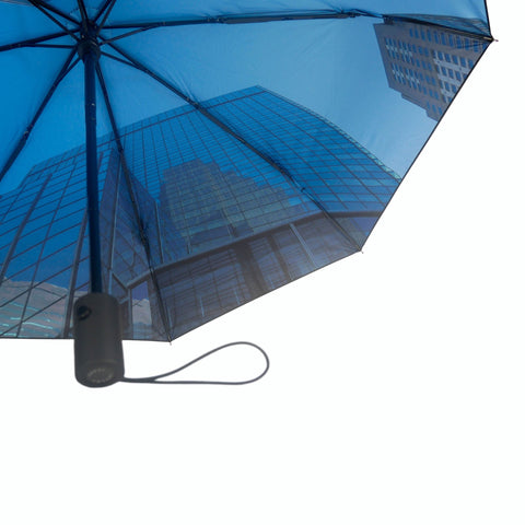 4. Close-up of city umbrella's blue cityscape pattern with black handle, emphasizing urban elegance