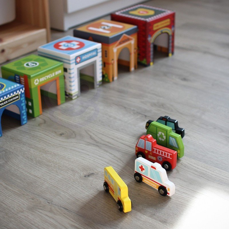 4. Close-up of colorful city-themed puzzle cubes and wooden vehicles on a wooden floor