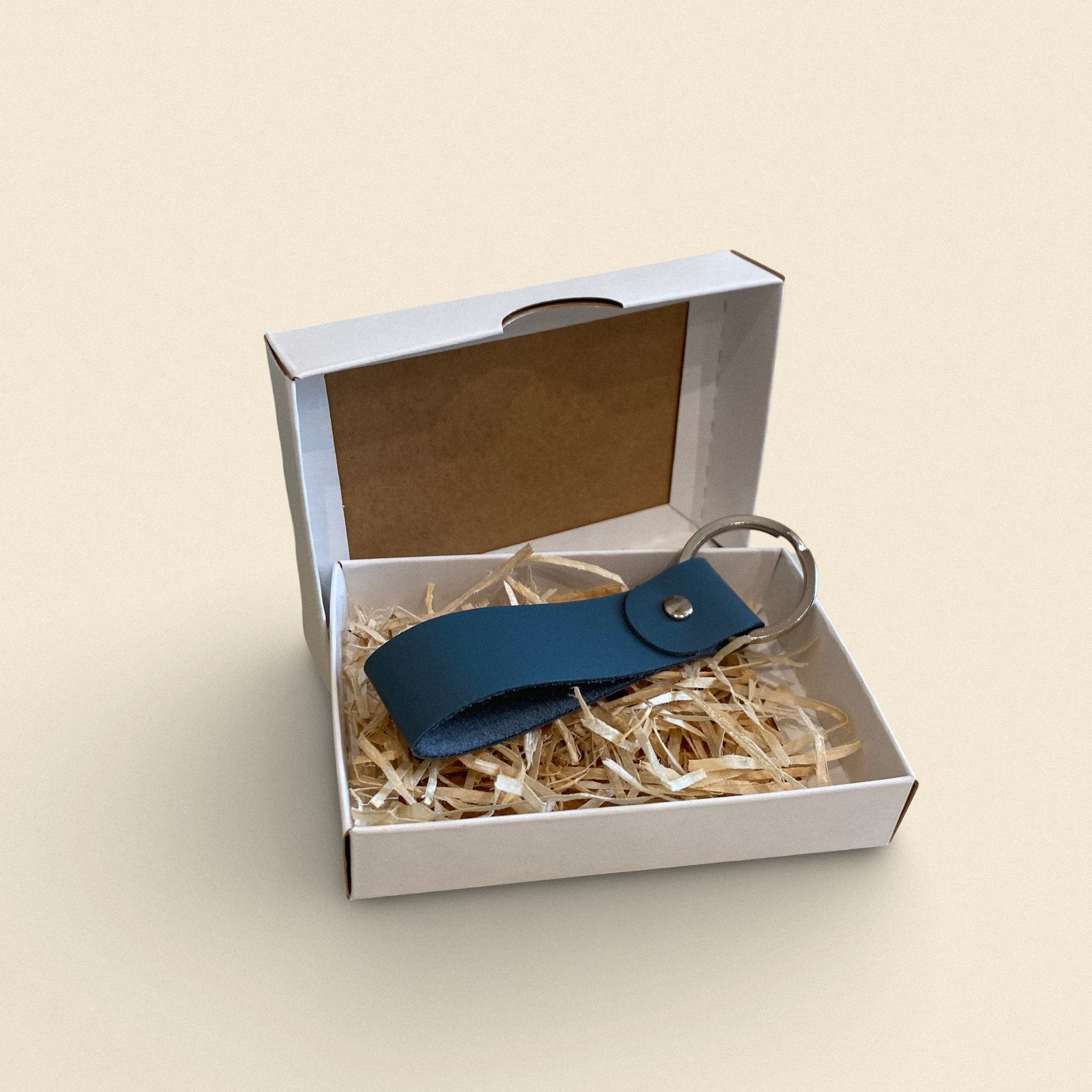 7. Blue-gray handmade leather keychain by Yoru in white gift box with straw filling
