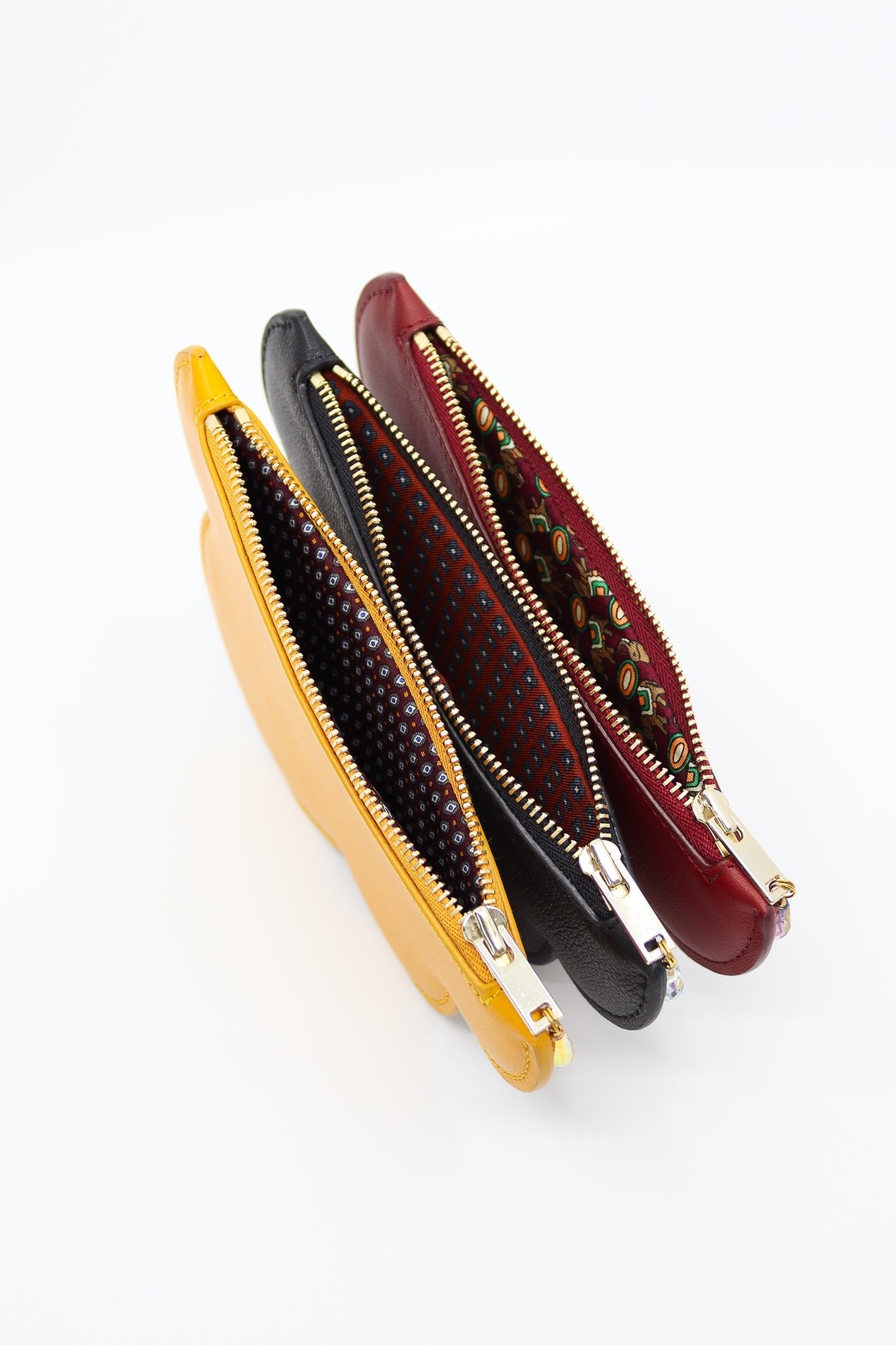 3. Trio of Tairi Roosve cloud purses in yellow, navy, and red, showcasing unique silk linings