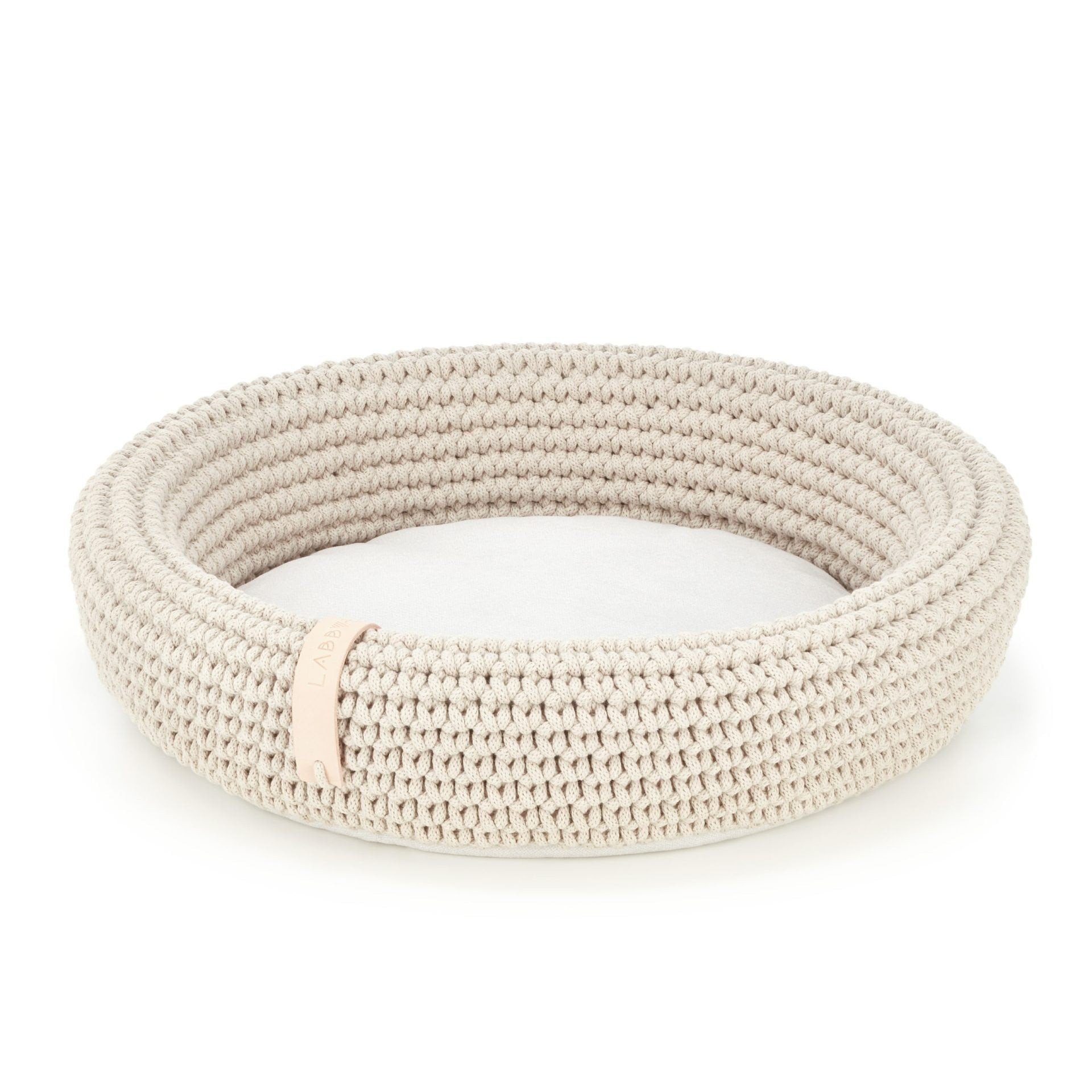 3. Studio shot of beige Labbvenn Coco pet bed made from hand-woven cotton rope with soft cushion, showing brand tag