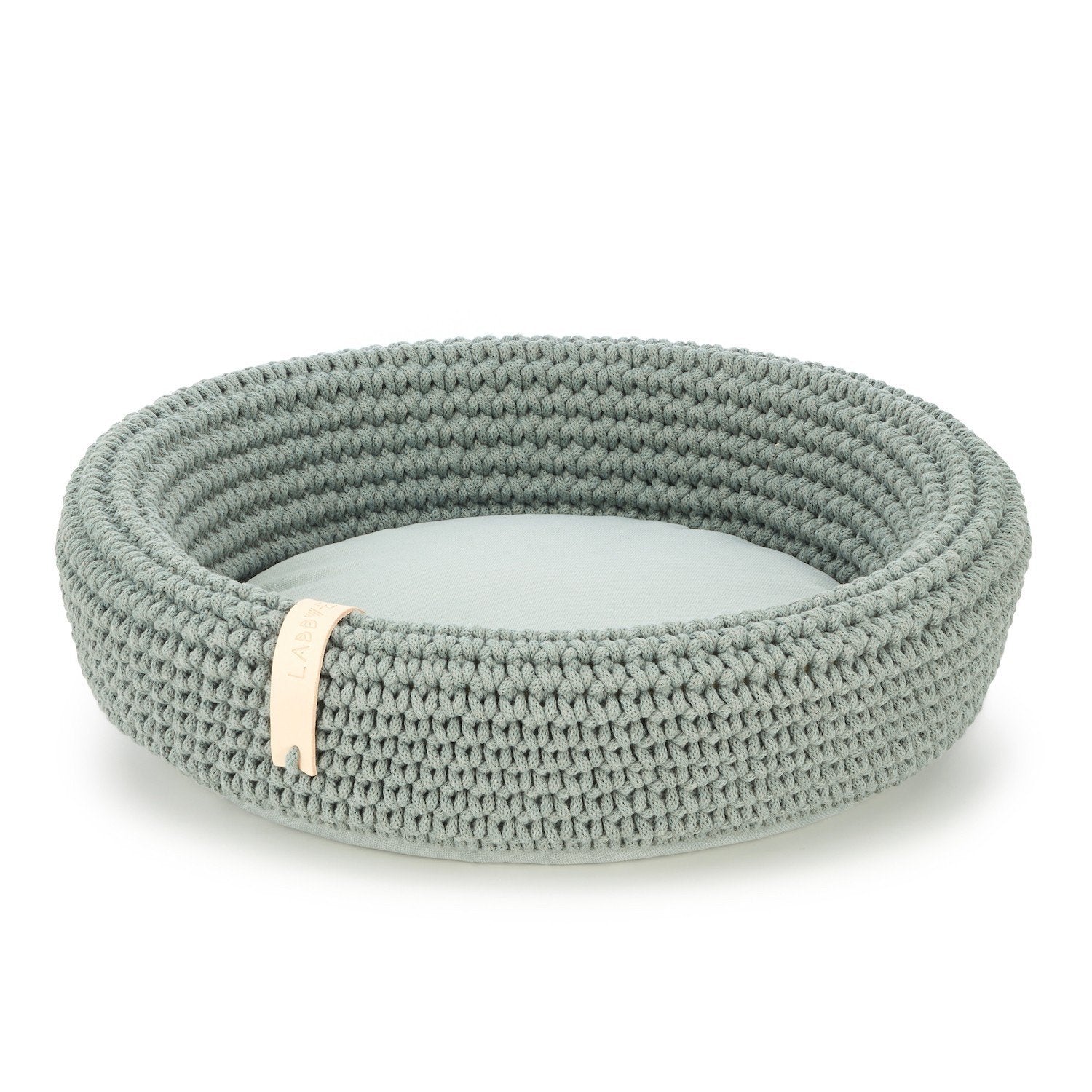 2. Green hand-woven pet bed made from Oeko-Tex cotton rope with soft polyester cushion, featuring Labbvenn logo tag, shown in studio setting