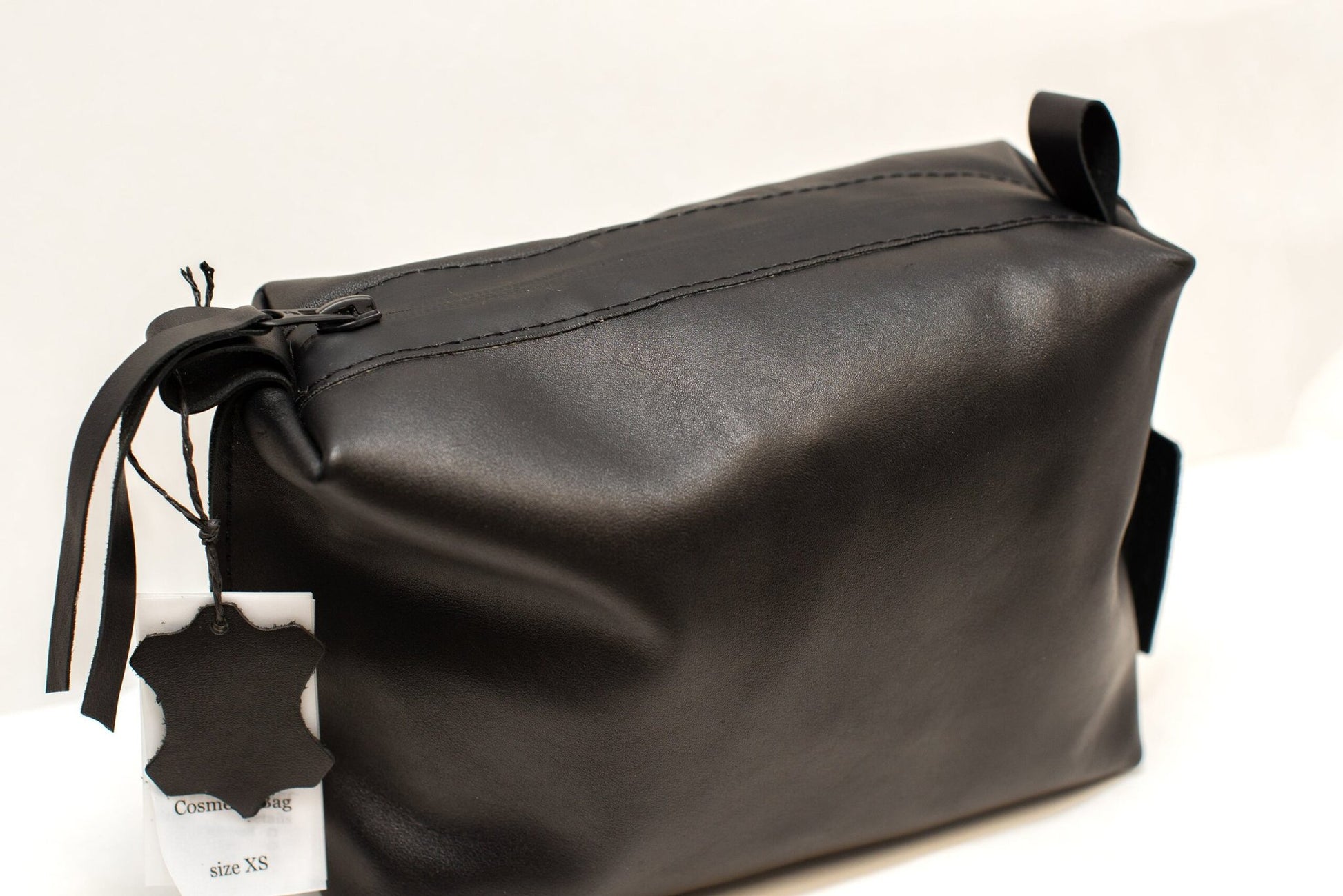 8. Close-up of Zelma Kraft black leather cosmetic bag, highlighting zipper and leather quality