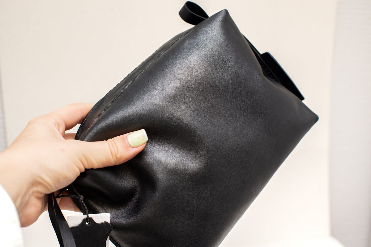 6. Close-up of Zelma Kraft black leather cosmetic bag, showing smooth texture and metal accents