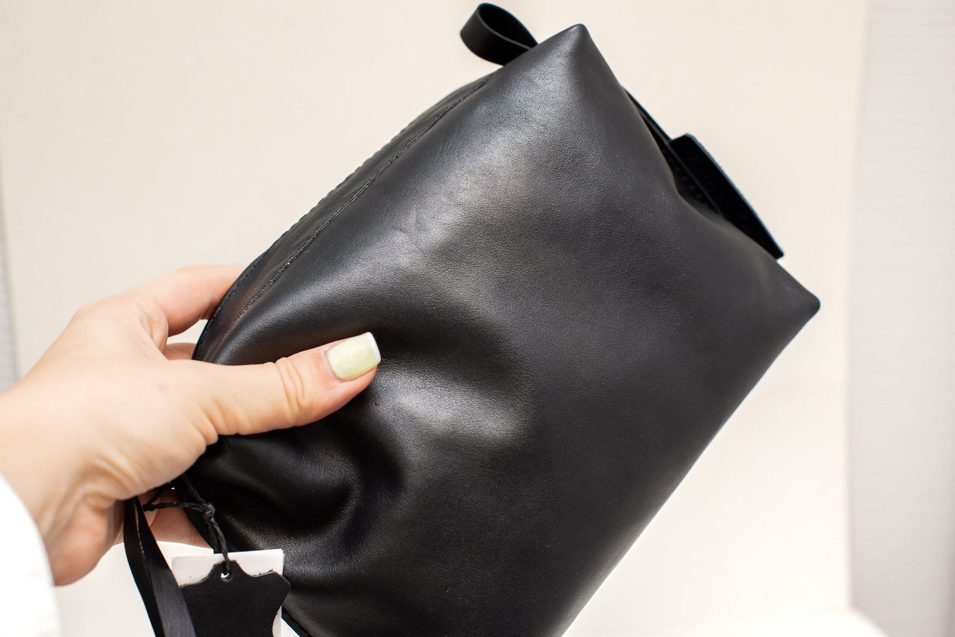 6. Close-up of Zelma Kraft black leather cosmetic bag, showing smooth texture and metal accents