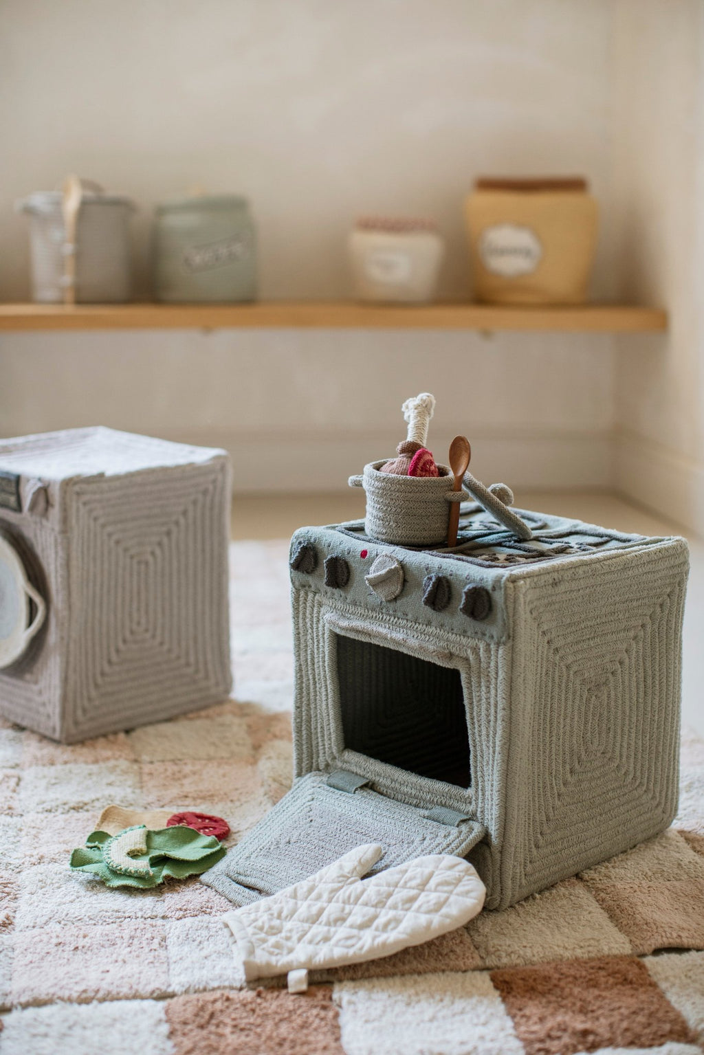 10. Lorena Canals blue sage textile toy stove with open oven door and accessories on rug