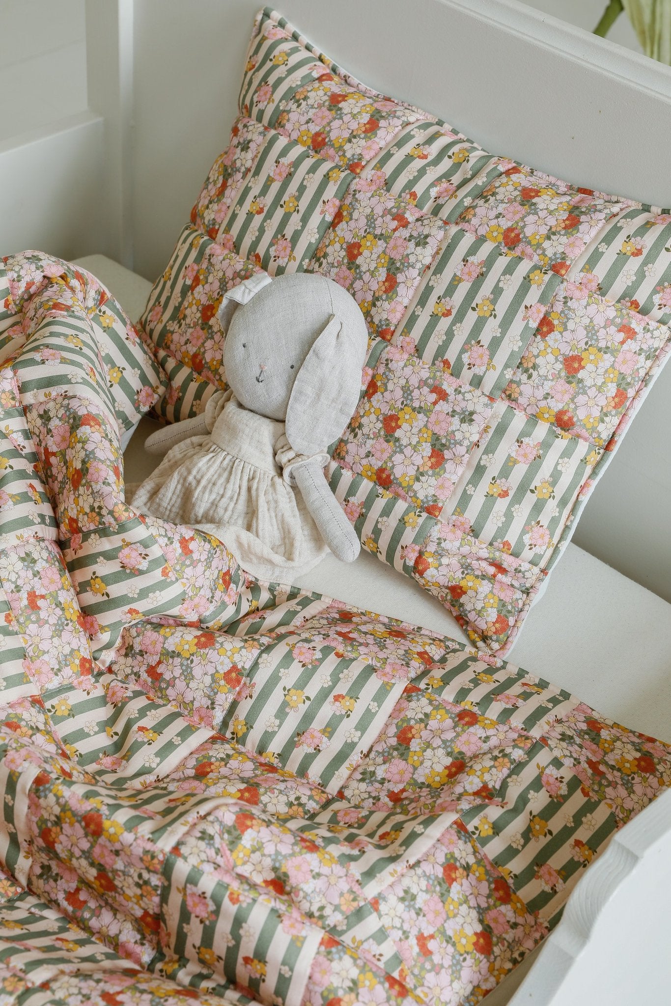 2. Cotton quilted patchwork blanket and pillow set with a stuffed toy on a bed