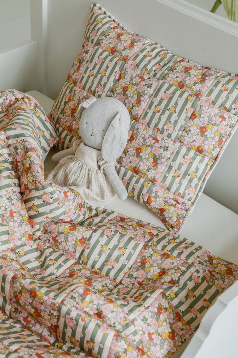 2. Cotton quilted patchwork blanket and pillow set with a stuffed toy on a bed