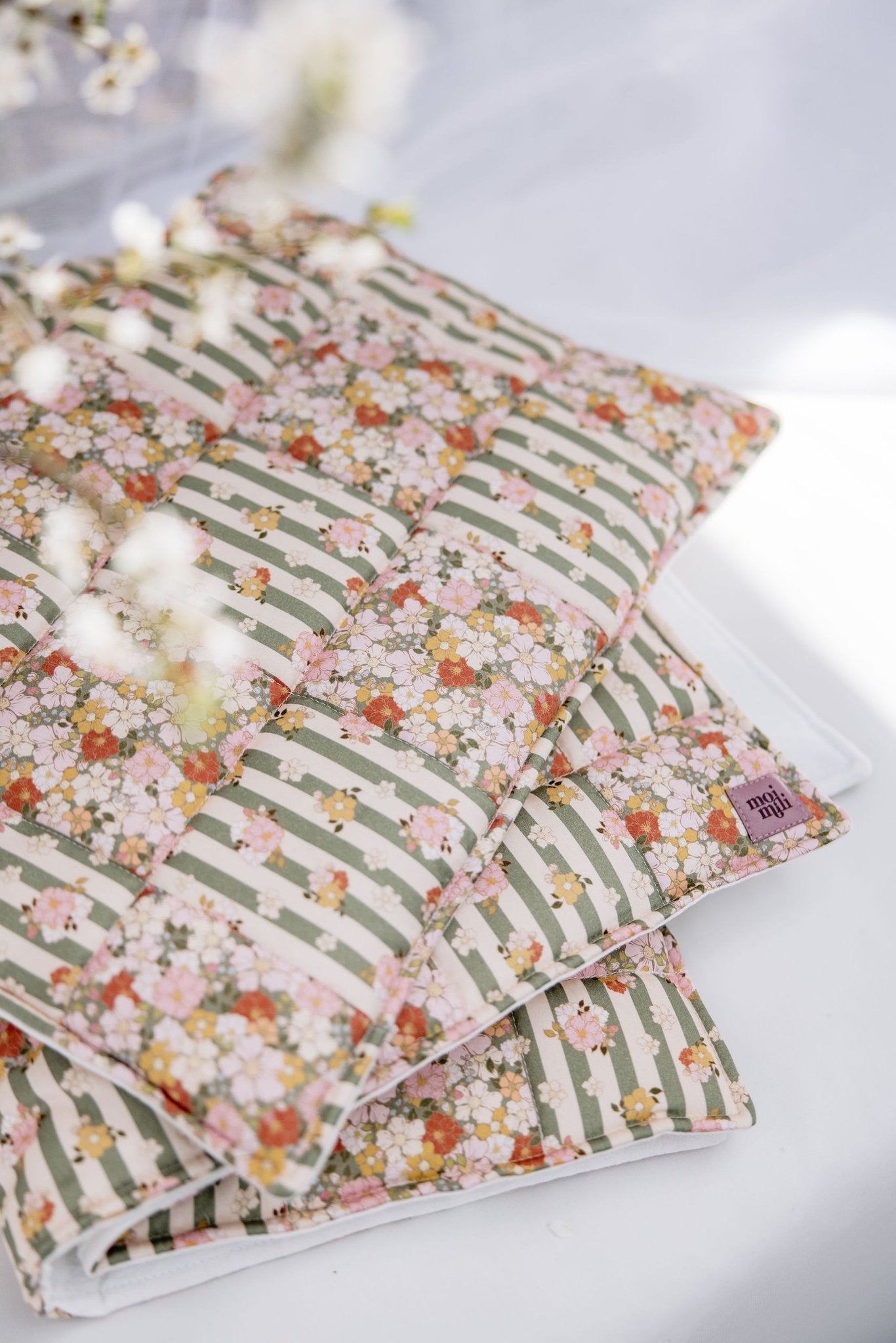6. Close-up of cotton quilted patchwork blanket in green garden pattern with floral details