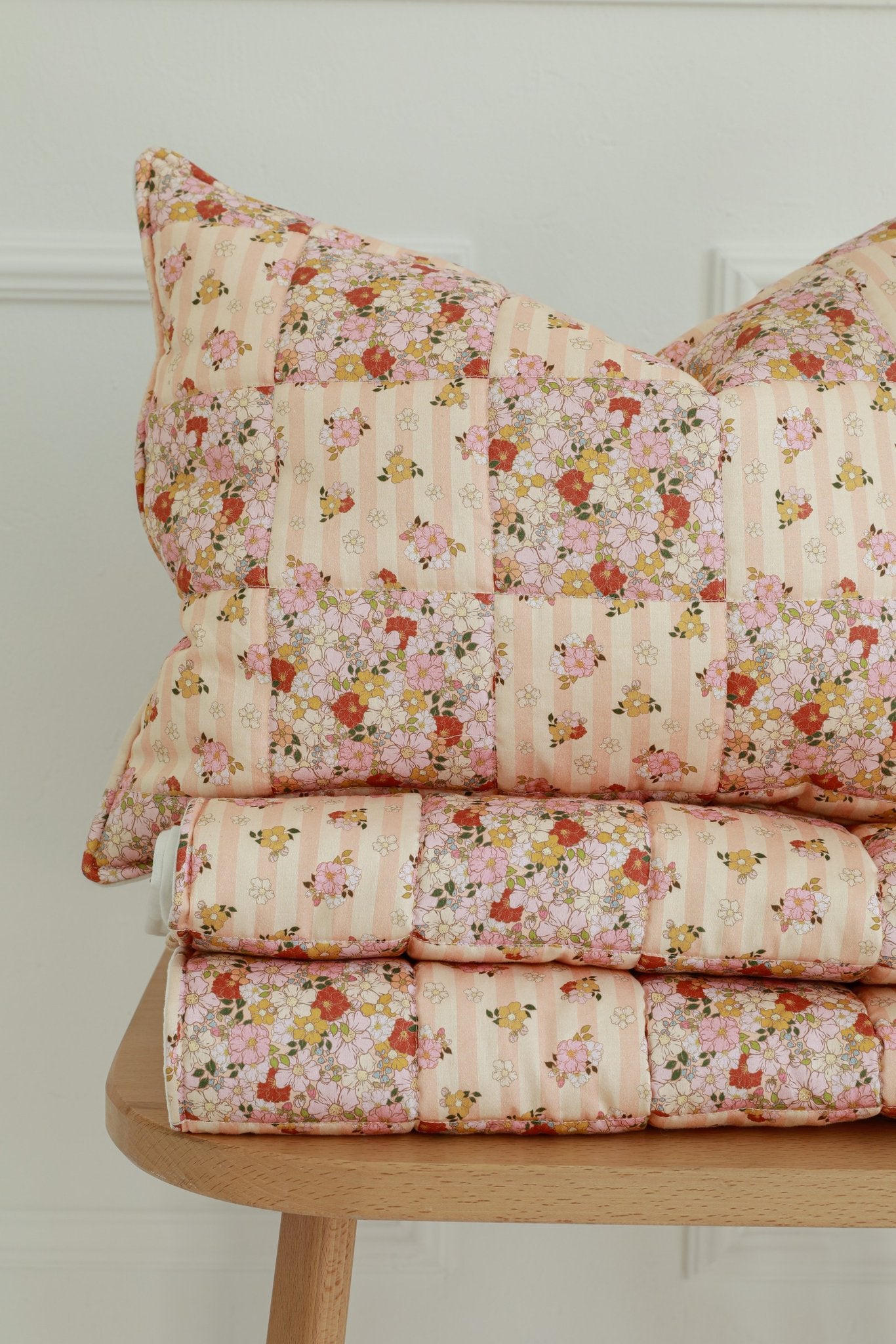 5. Stacked floral cotton quilted blanket and pillow set on wooden stool highlighting patchwork design