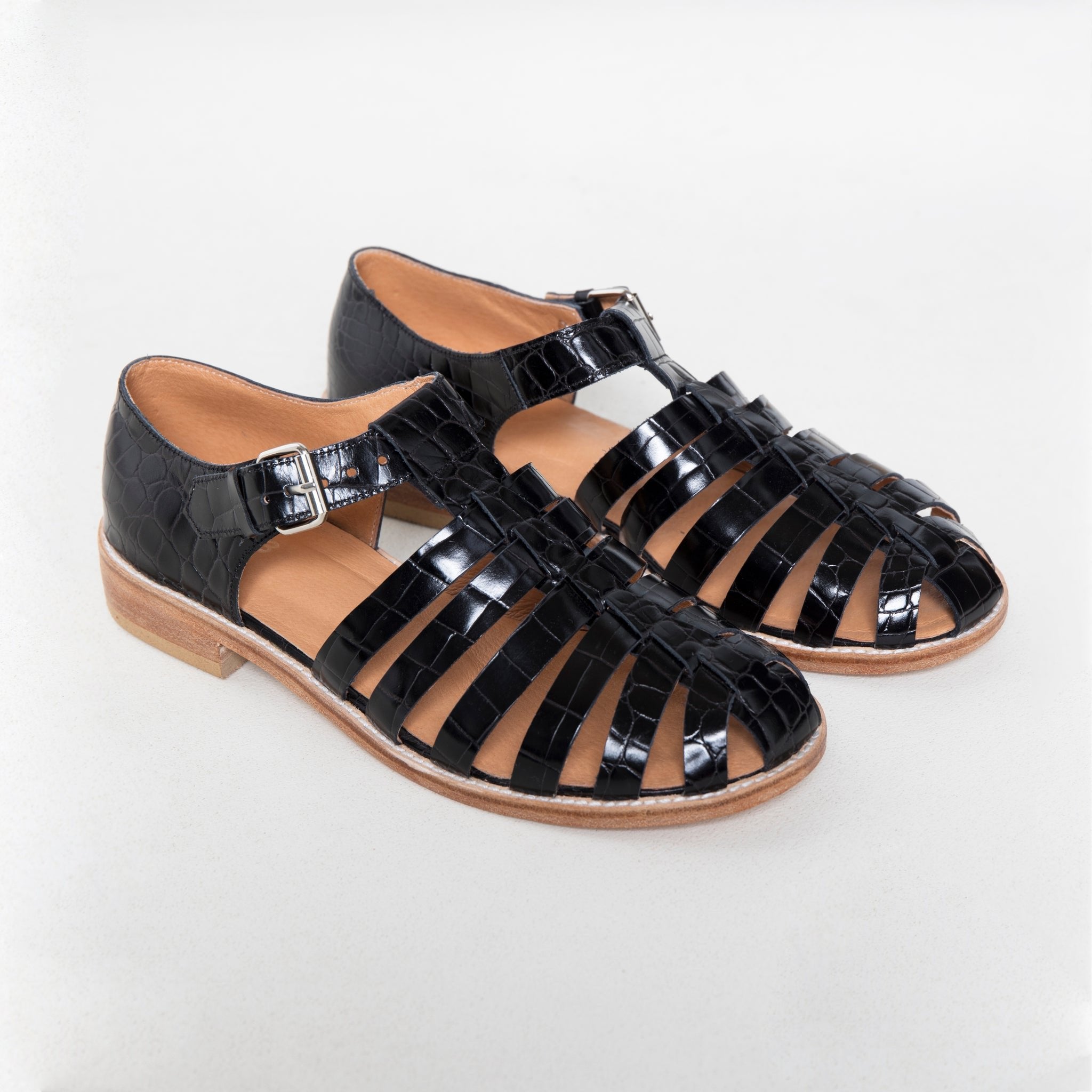 4. Studio image of black croc fisherman sandals with round toe and 3/4 stacked leather heel