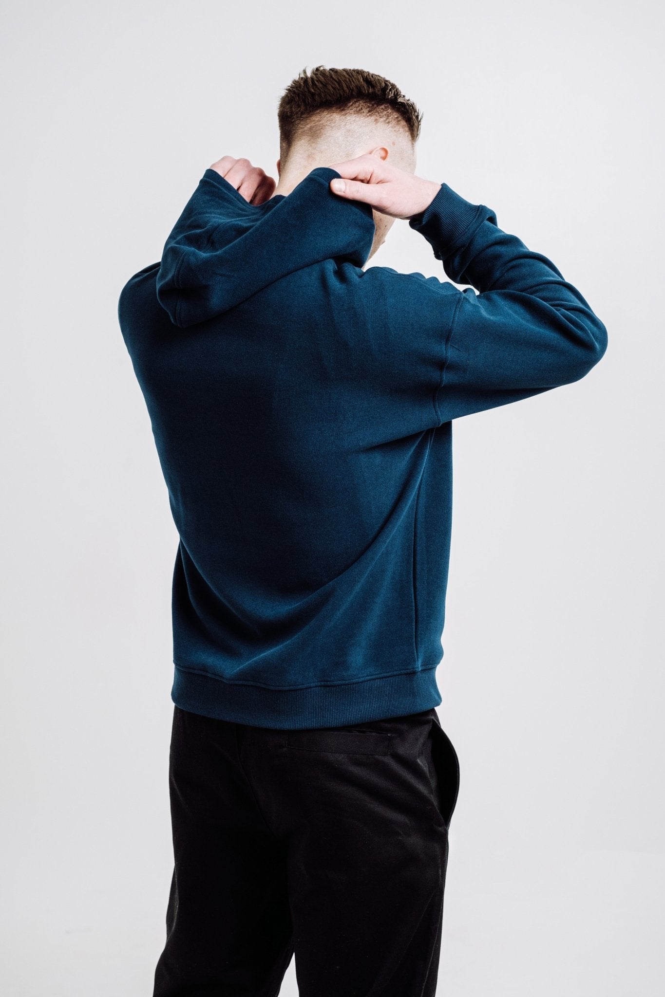 4. Back view of unisex Deer Hoodie in Indigo Blue worn by male model, highlighting relaxed fit