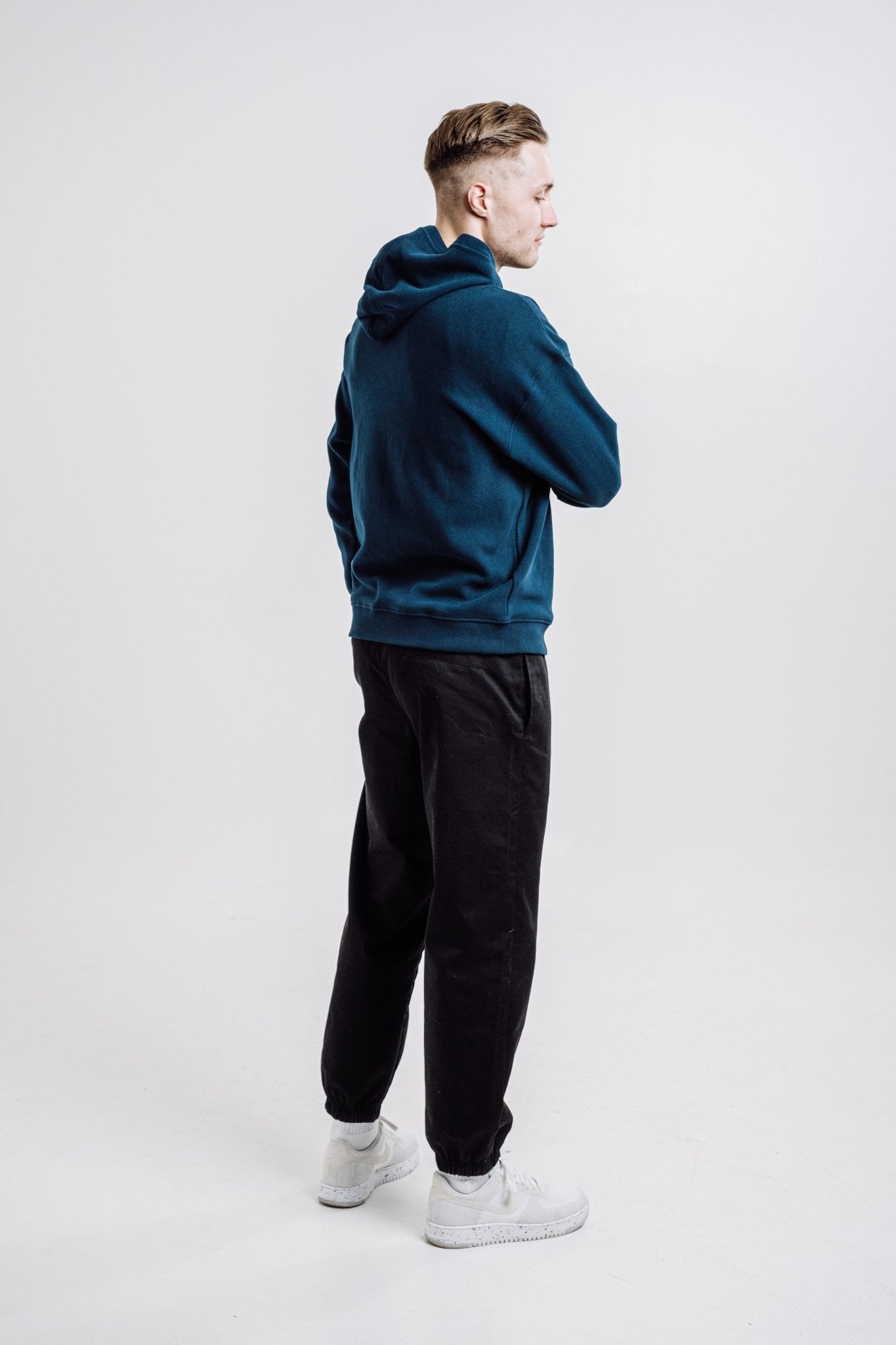 6. Side view of unisex Deer Hoodie in Indigo Blue worn by male model, highlighting back and hood