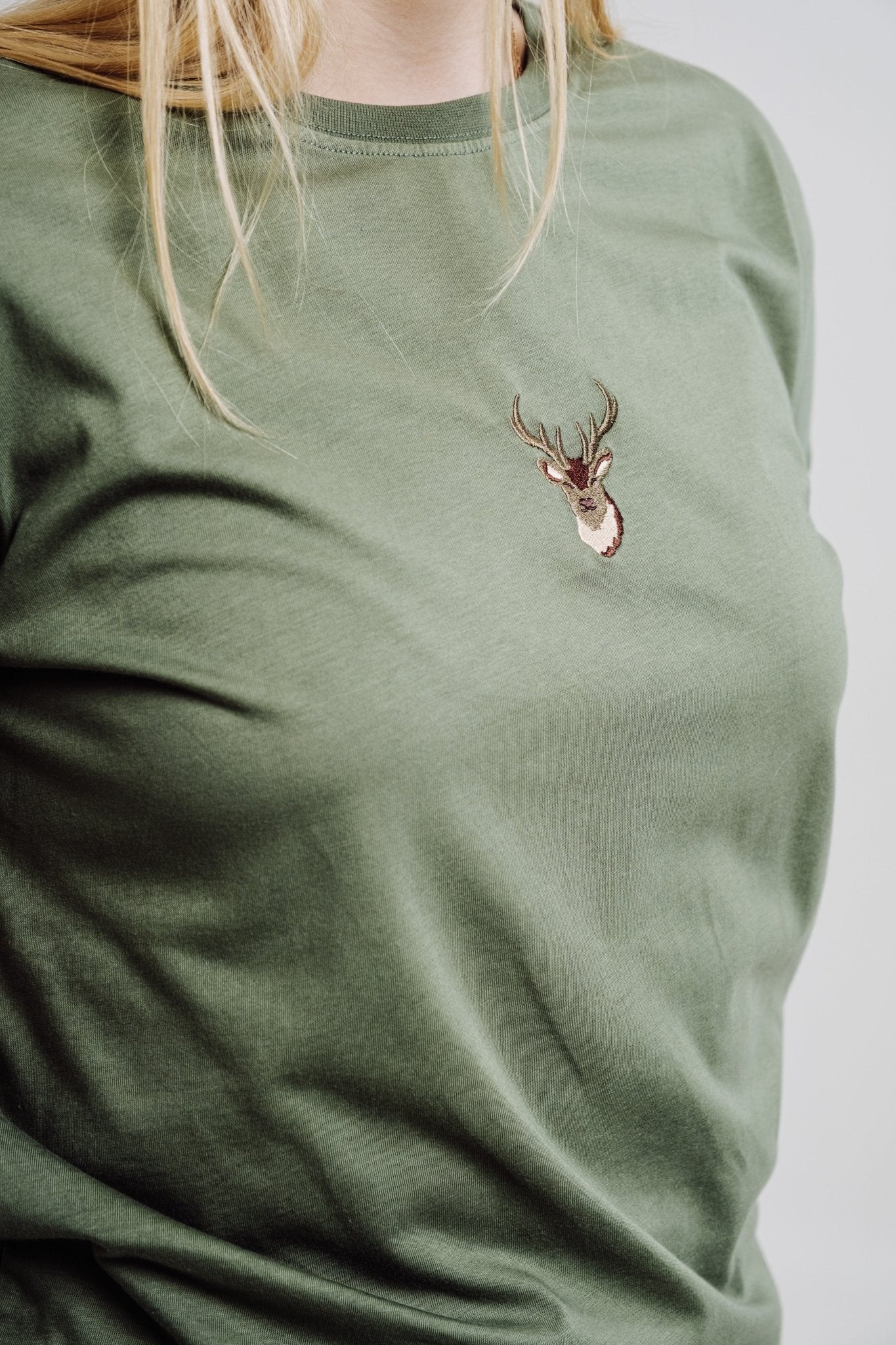 5. Close-up of khaki Sossu T-shirt on female model, focusing on embroidered deer design