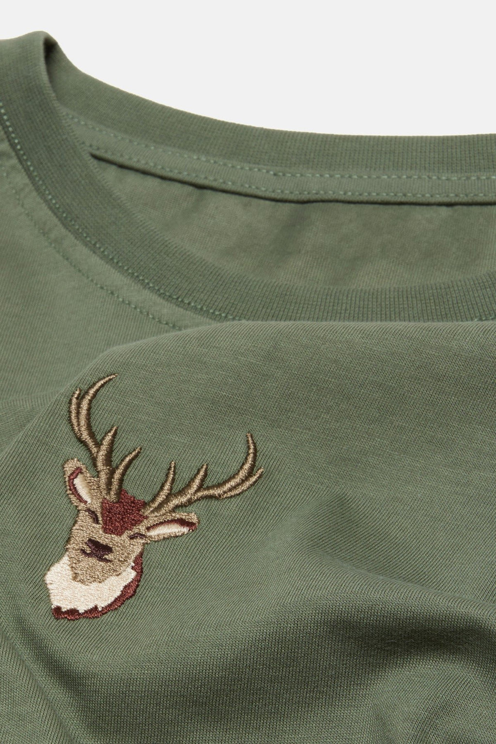 3. Close-up of embroidered deer design on khaki Sossu T-shirt, showing detailed stitching
