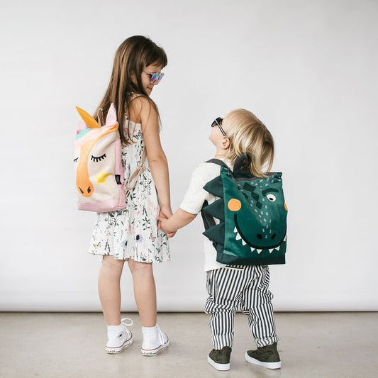 1. Kids wearing Muni dinosaur and unicorn backpacks, lifestyle setting