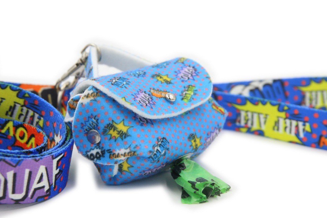 1. Blue graffiti dog waste bag dispenser with matching leash, featuring colorful comic motifs and metal eyelet, shown with green bag partially pulled out.