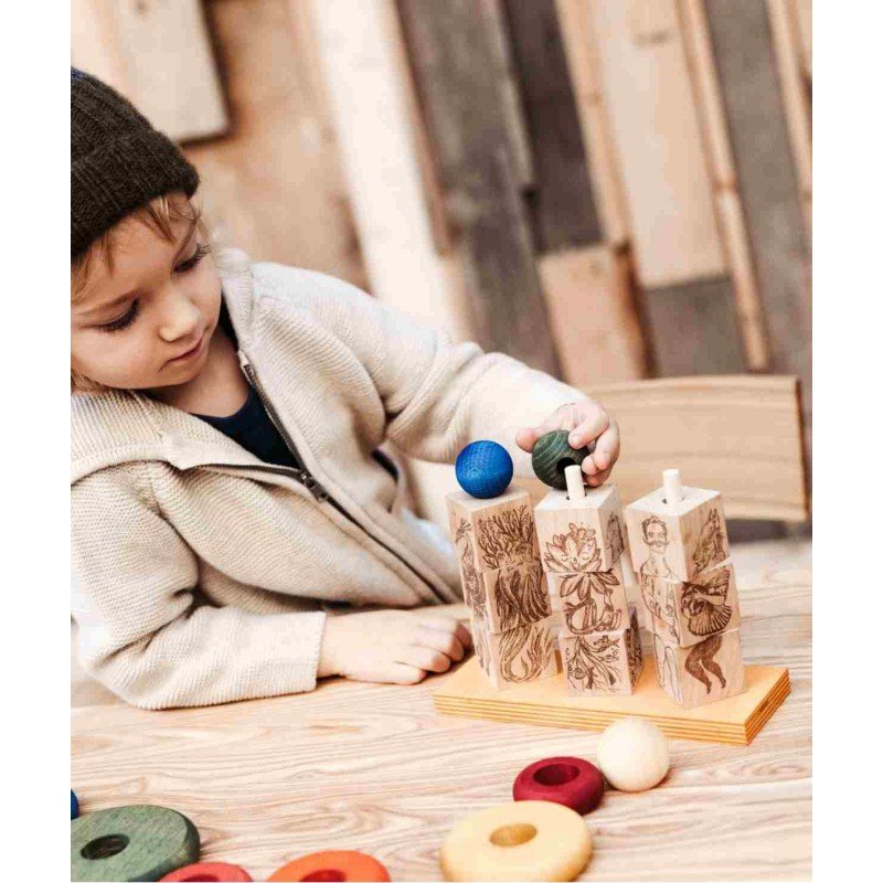 1. Child playing with Wooden Story Dreamland Spinner Puzzle, arranging blocks with engraved characters on a wooden table
