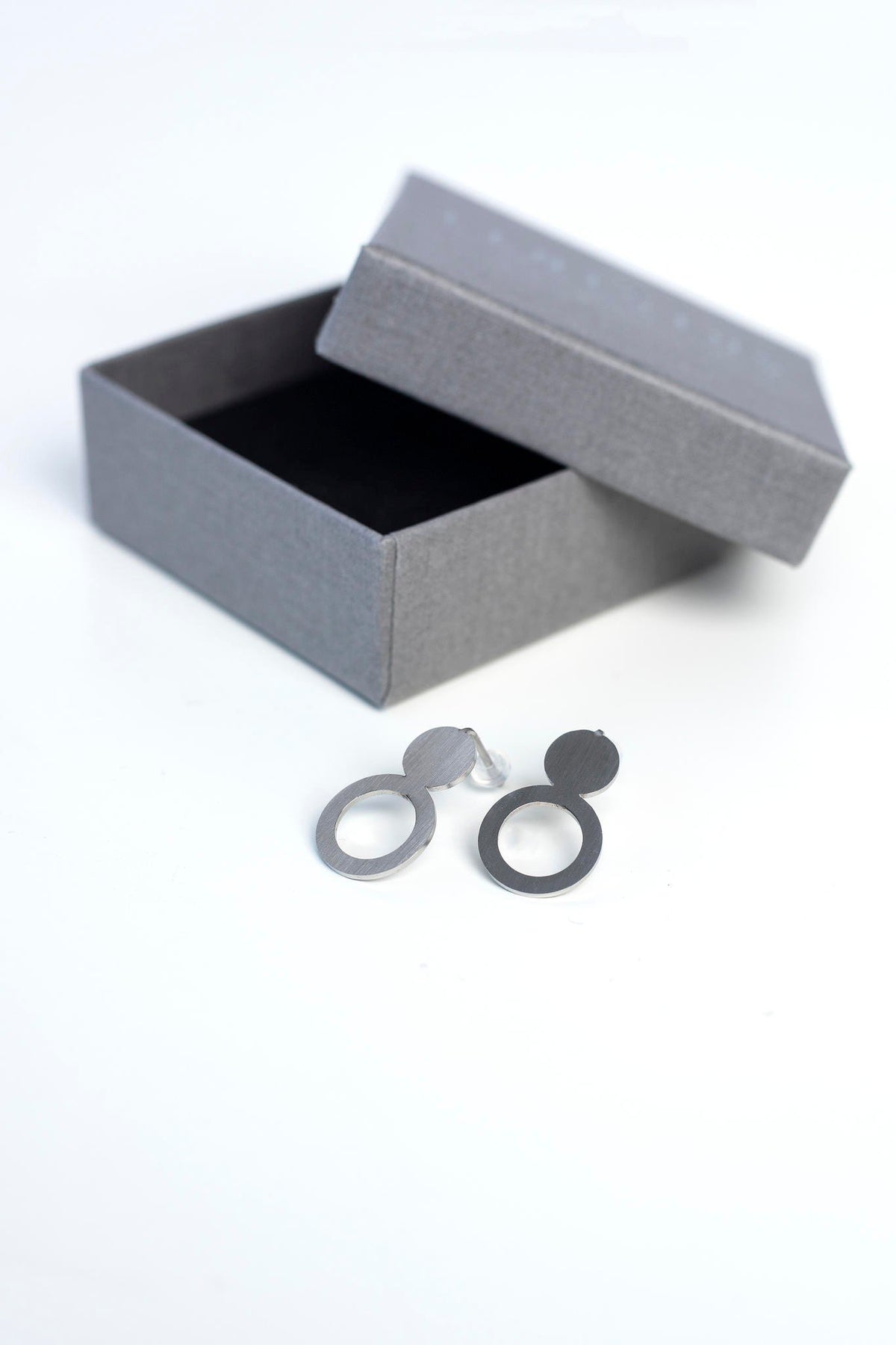 4. Flat lay of Lentsius silver stainless steel earrings with gift box and eco-velvet lining