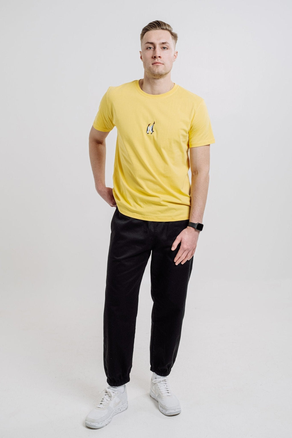 5. Unisex yellow Emperor Penguin T-shirt by Sossu worn by male model, highlighting front design