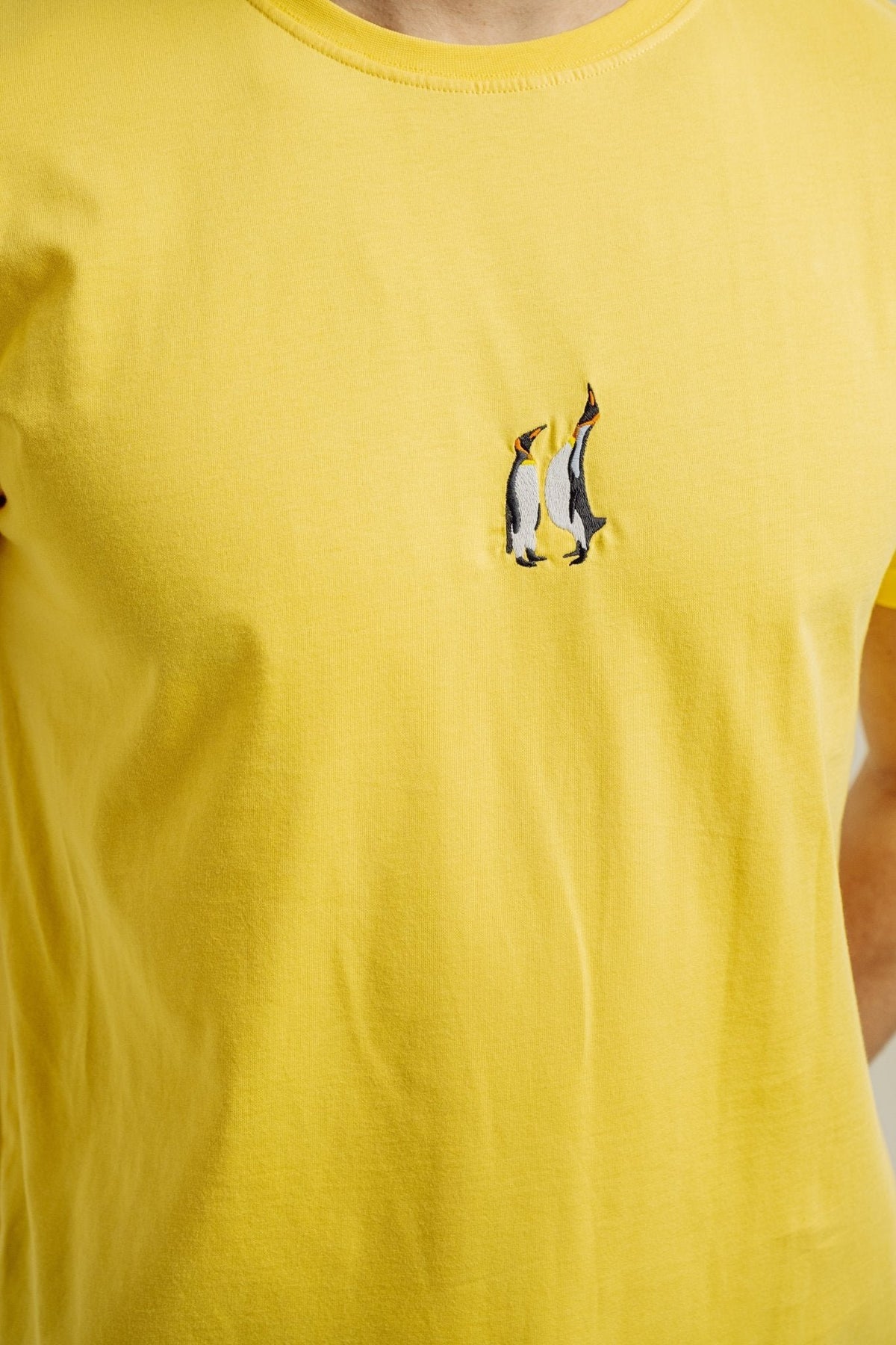 7. Close-up of penguin embroidery on yellow Emperor Penguin T-shirt by Sossu