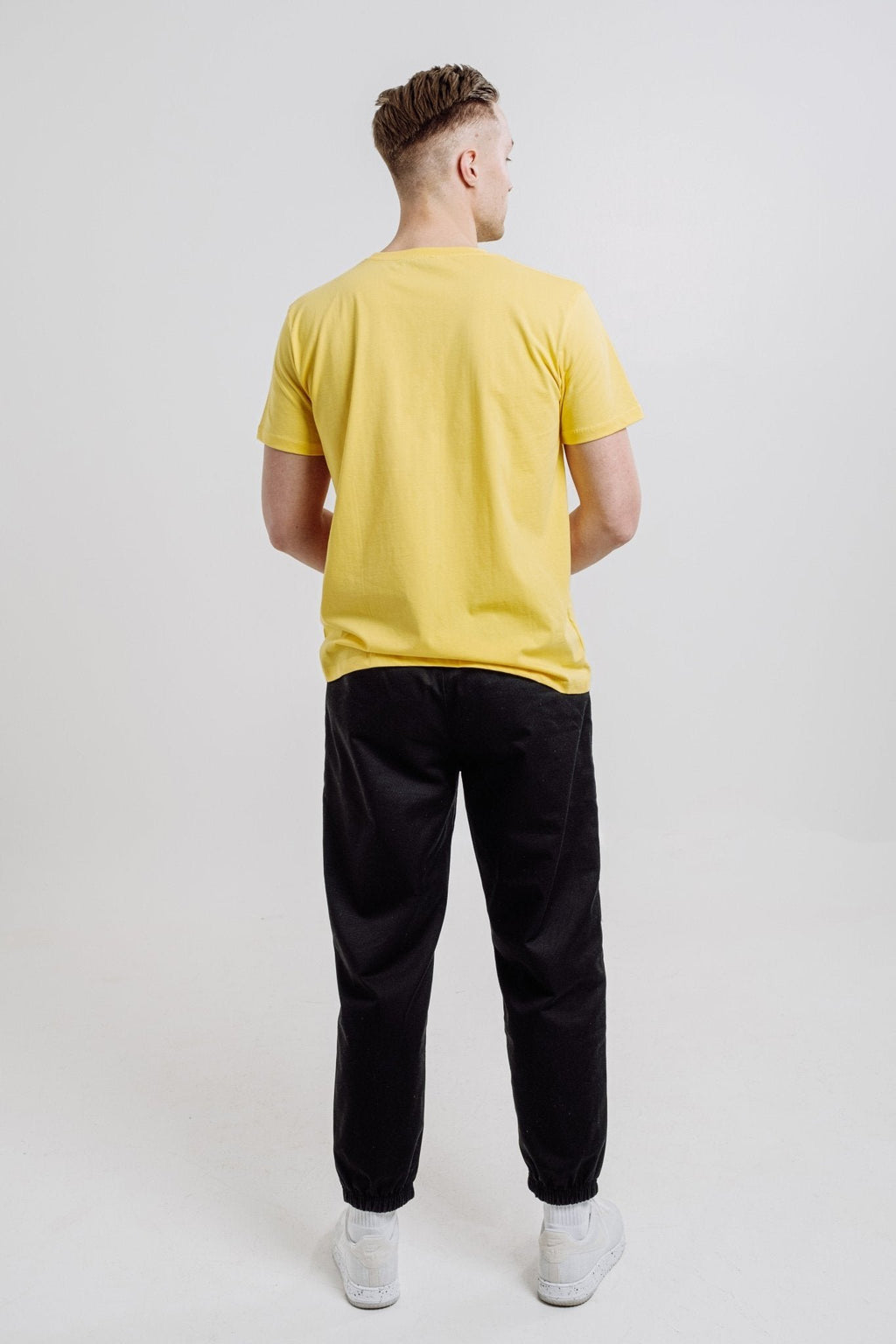 4. Back view of unisex yellow Emperor Penguin T-shirt by Sossu, shown in studio setting