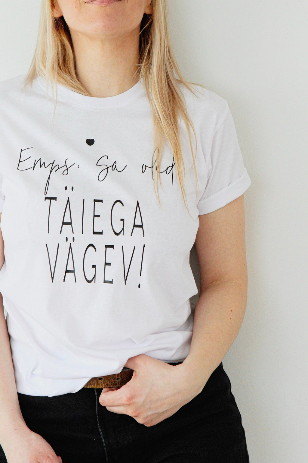 2. Close-up of woman wearing Black Giraffe Brand white T-shirt with 'Emps, sa oled täiega vägev' text, showing rolled-up sleeves