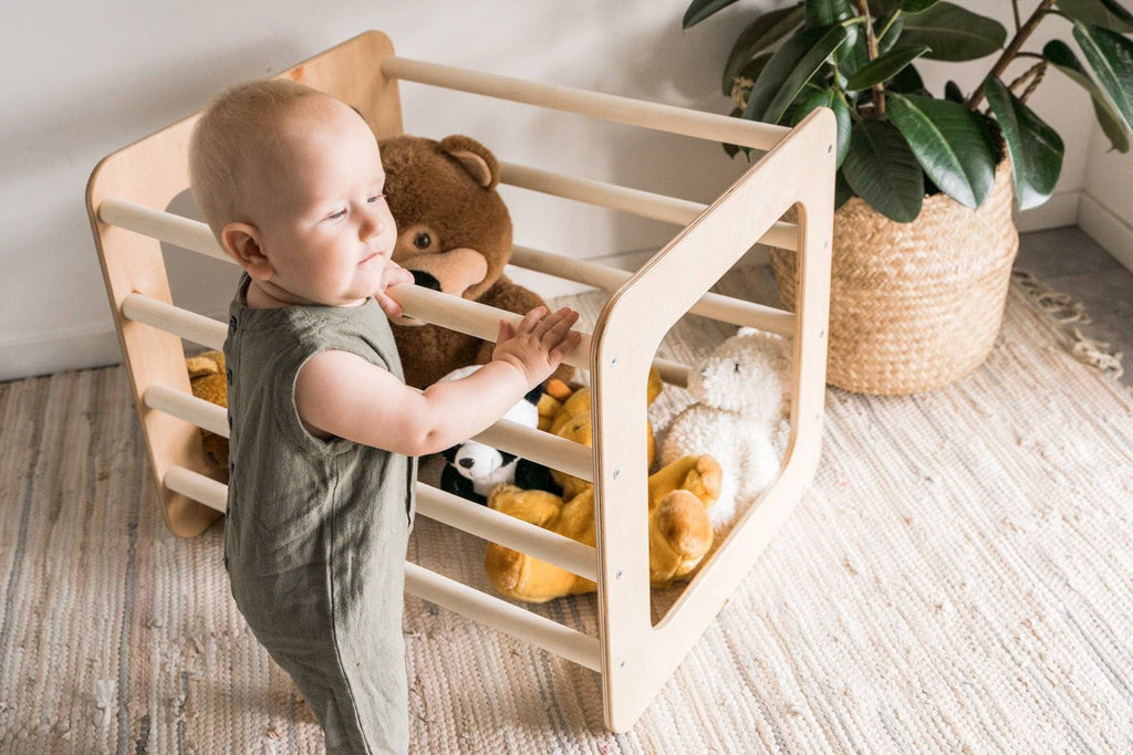 1. Toddler interacting with Ewart Woods square gym filled with toys on a woven rug